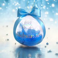 Bombka świąteczna z przezroczystego akrylu produkcji polskiej o średnicy 12 cm. W kuli zamknięte niebieskie piórka, a na bombke personalizacja bombki w postaci imienia Aleksander i grafiki mikołaja w kolorze holograficznym. Na górze bombki przewiązana złota zawieszka do zawieszenia bombki oraz niebieska kokardka dodająca uroku.
