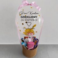 Balonbox z personalizowanym napisem "Pani Karolino, dziękujemy za wszystko" od przedszkolaków, z różową kokardą i złotymi konfetti, w koszu z upominkami i słodyczami
